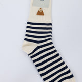 Navy and white striped sock with a visible brand label on a light gray background