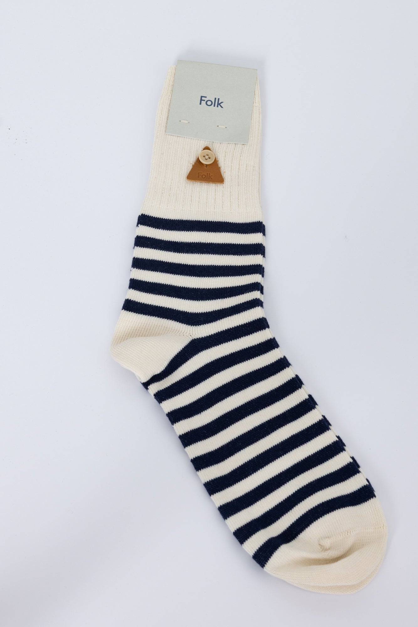 Navy and white striped sock with a visible brand label on a light gray background