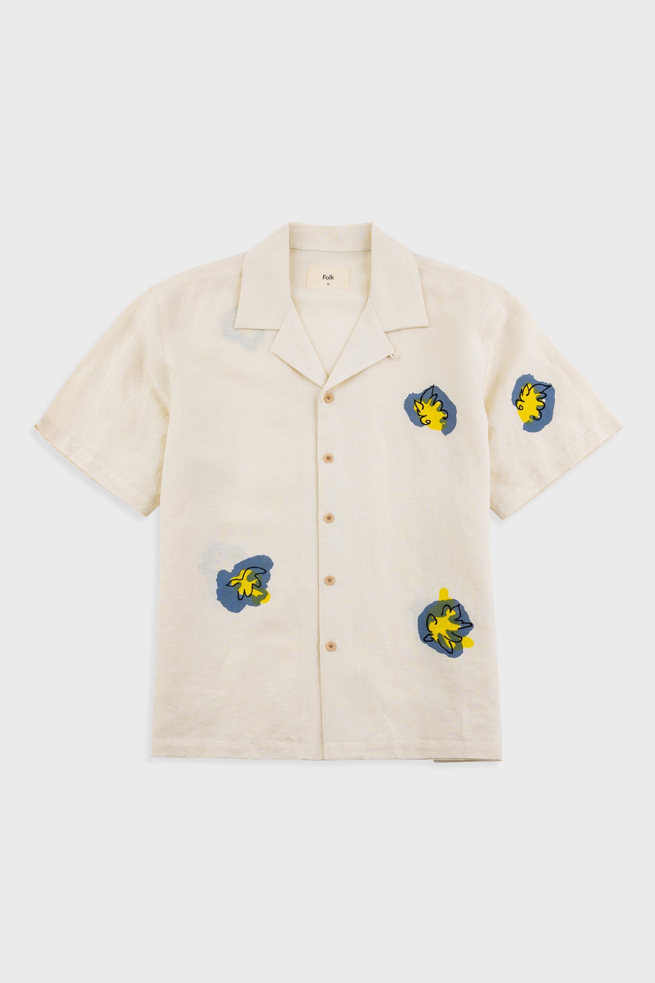 Beige shirt with embroidered designs on a white background