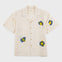 Beige shirt with embroidered designs on a white background