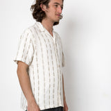 Man wearing a white striped shirt against a plain background