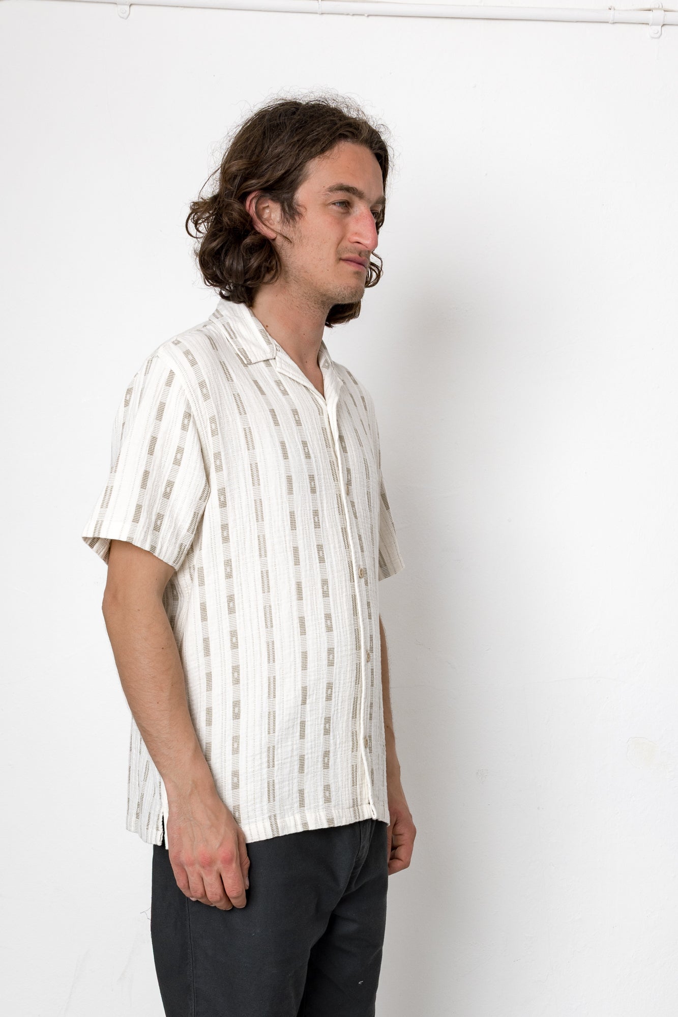 Man wearing a white striped shirt against a plain background