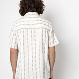 Person wearing a white striped shirt against a white background