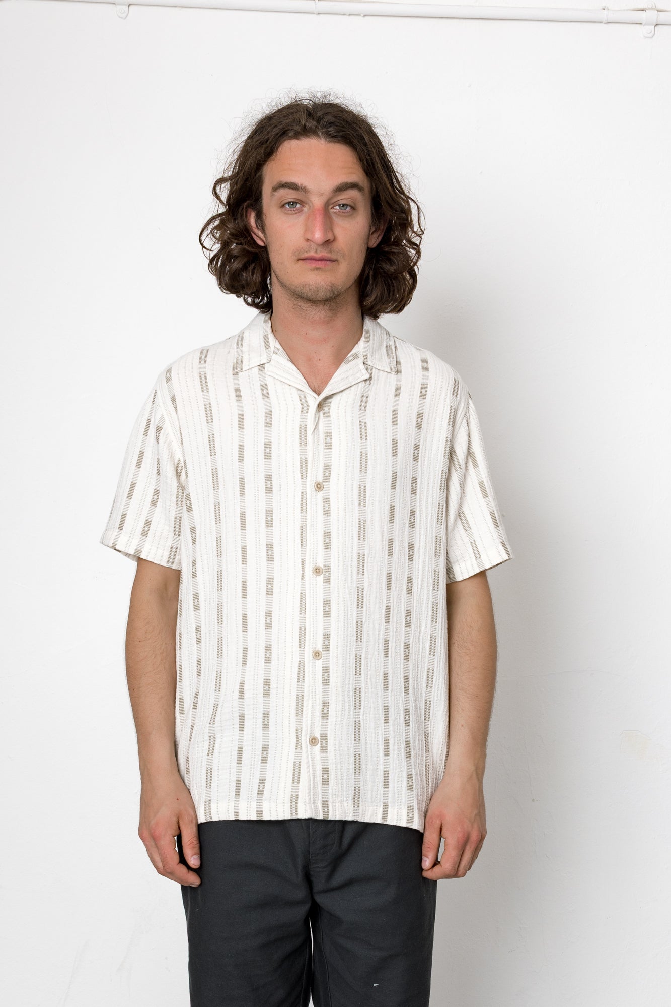 Man wearing a white striped shirt against a plain background