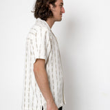 Man wearing a white striped shirt against a plain background