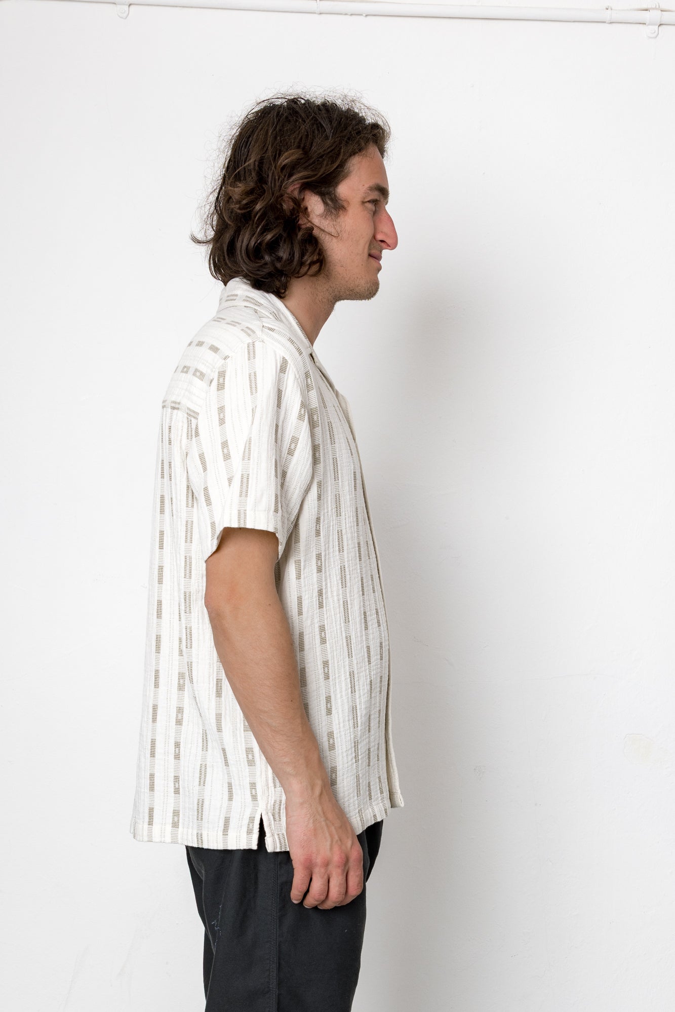 Man wearing a white striped shirt against a plain background