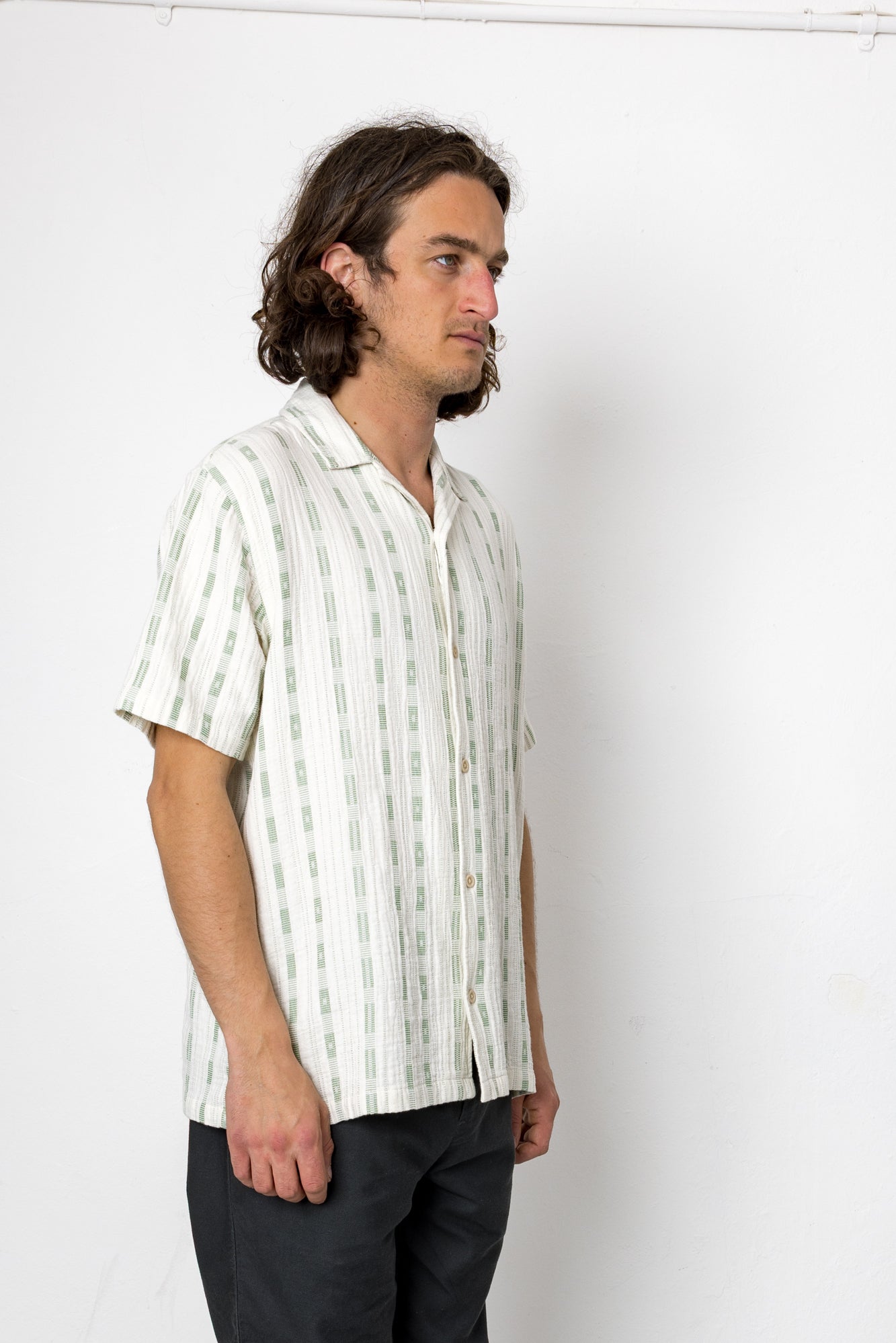 Man wearing a white striped shirt against a white background