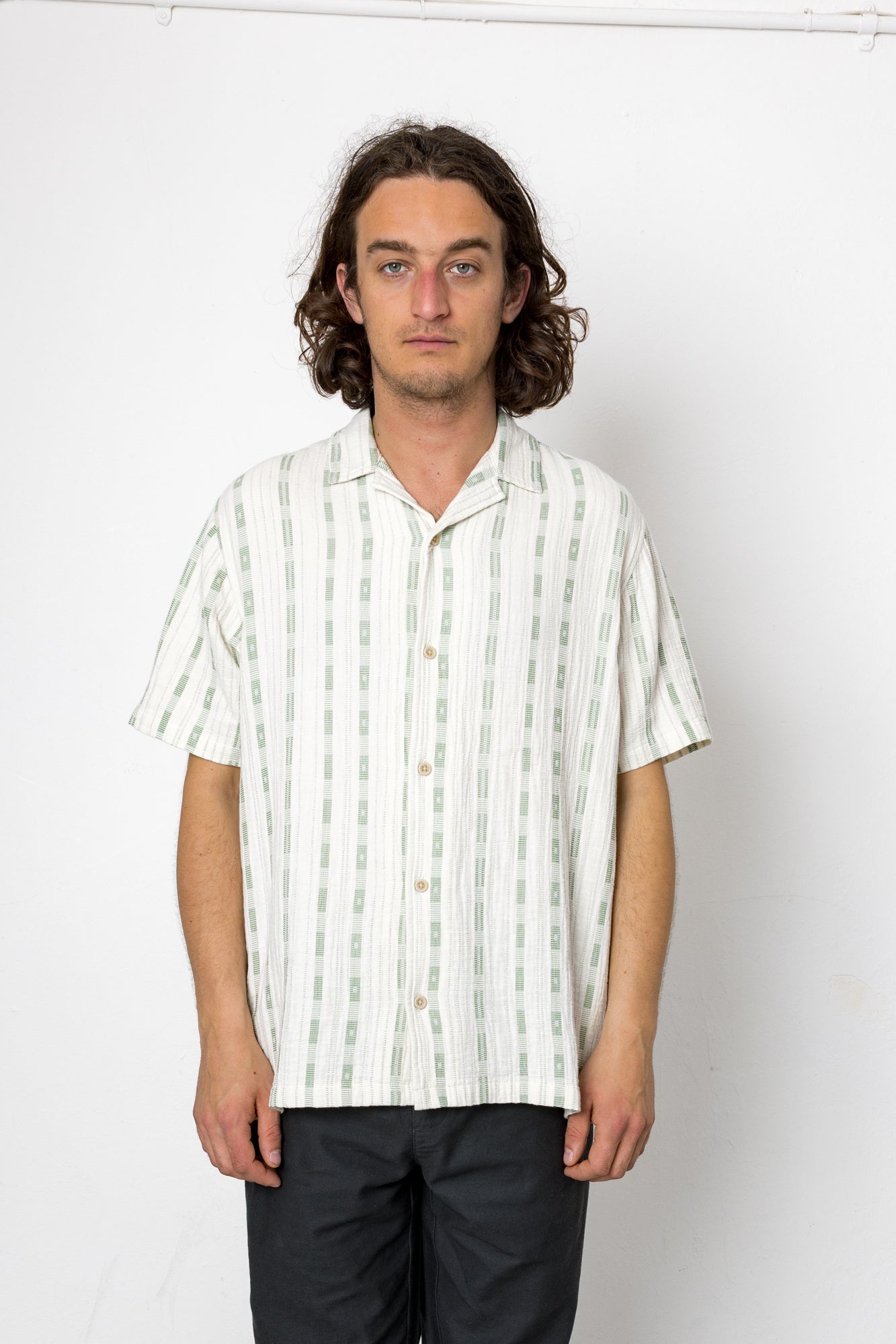 Man wearing a white striped shirt against a white background