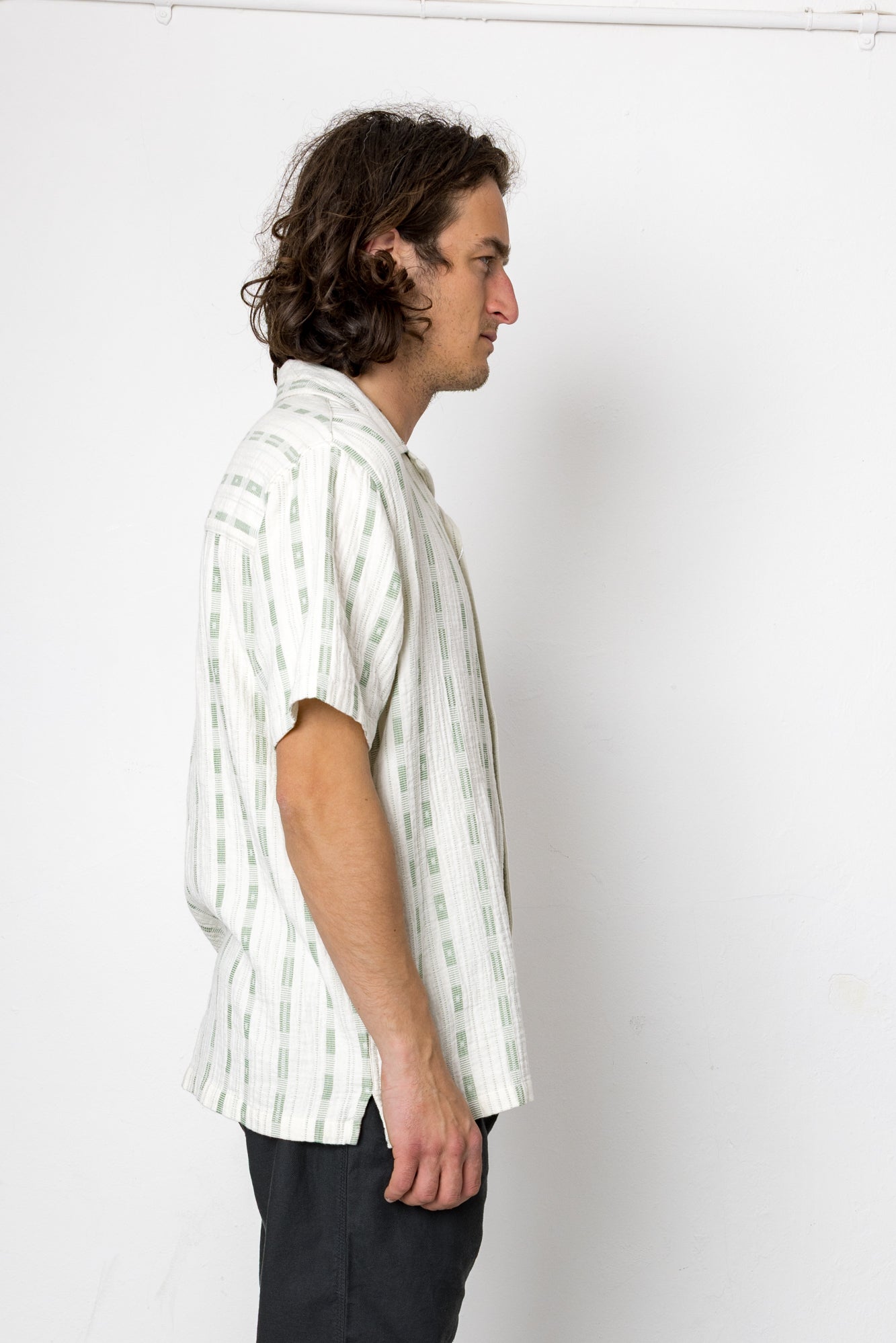 Man wearing a white striped shirt against a plain background