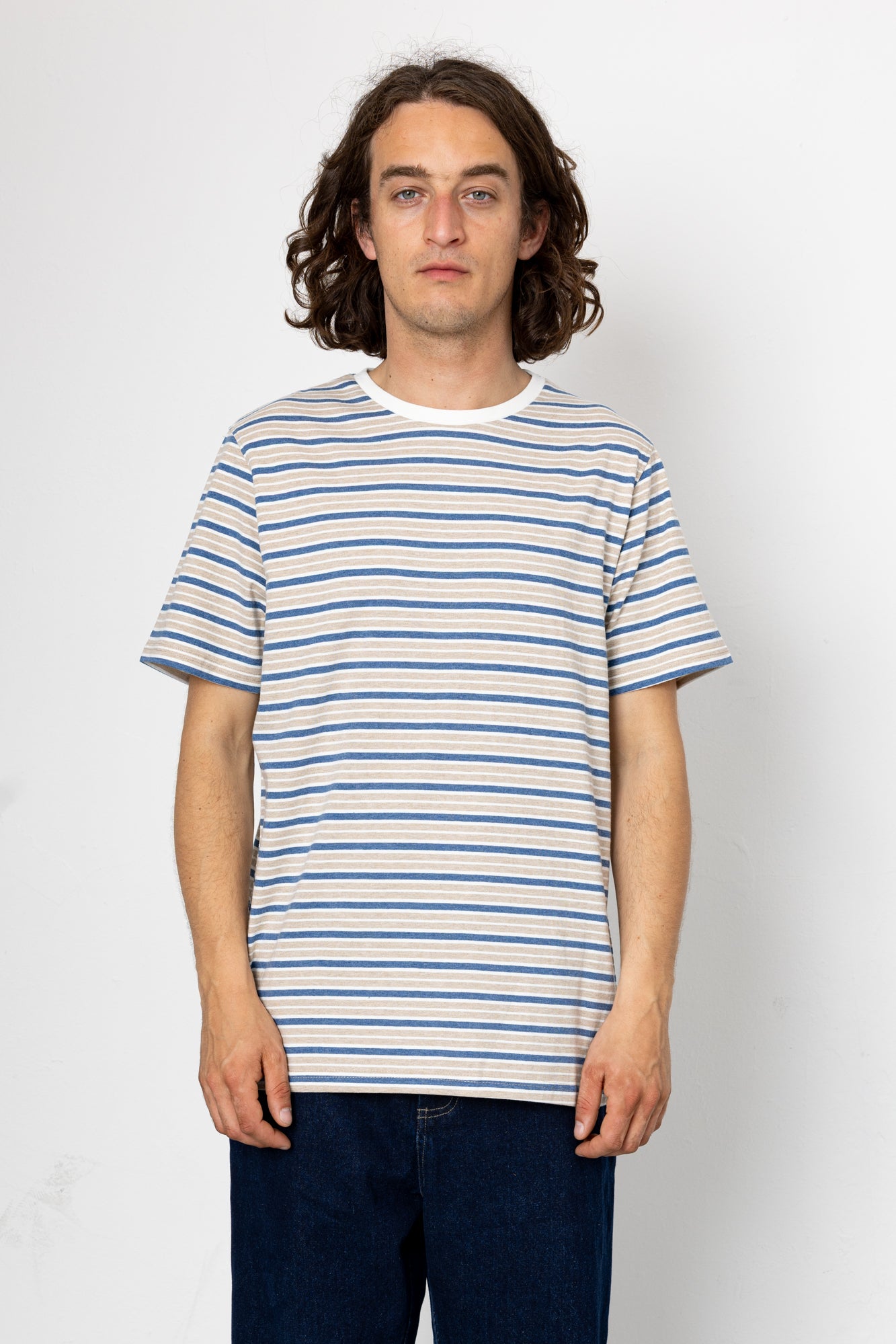Person wearing a blue and white striped t-shirt against a plain background