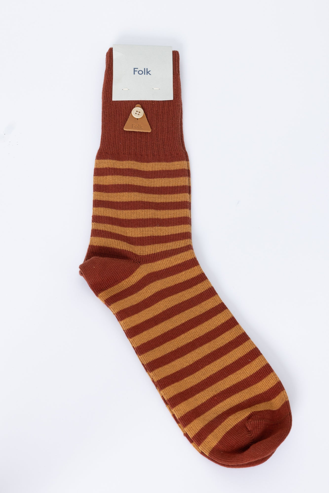 Brown and beige striped sock with 'Folk' label on a white background