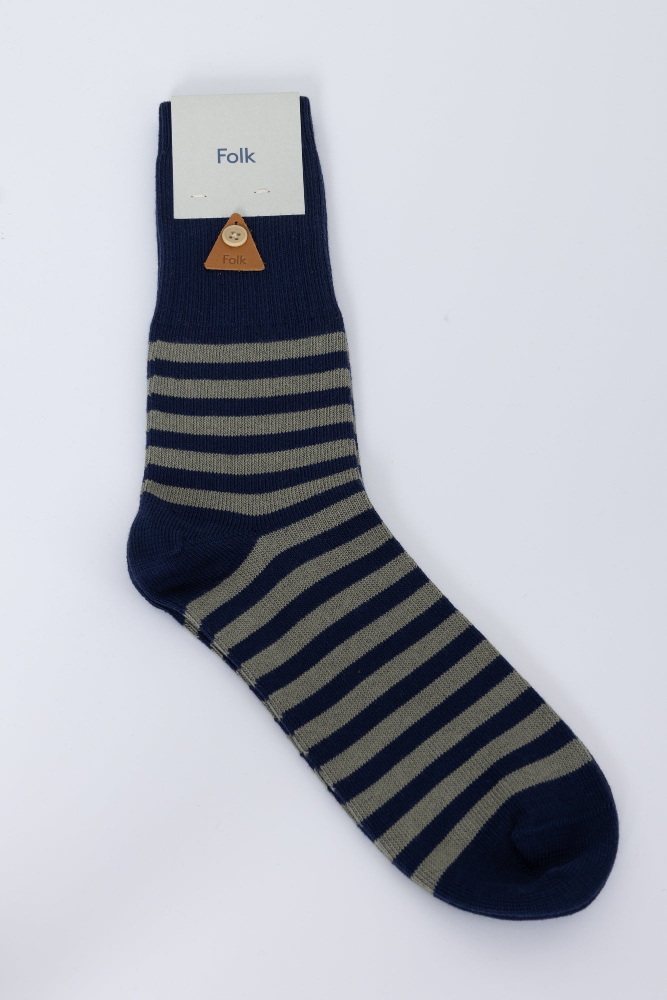 Navy and beige striped sock with 'Folk' label on a white background