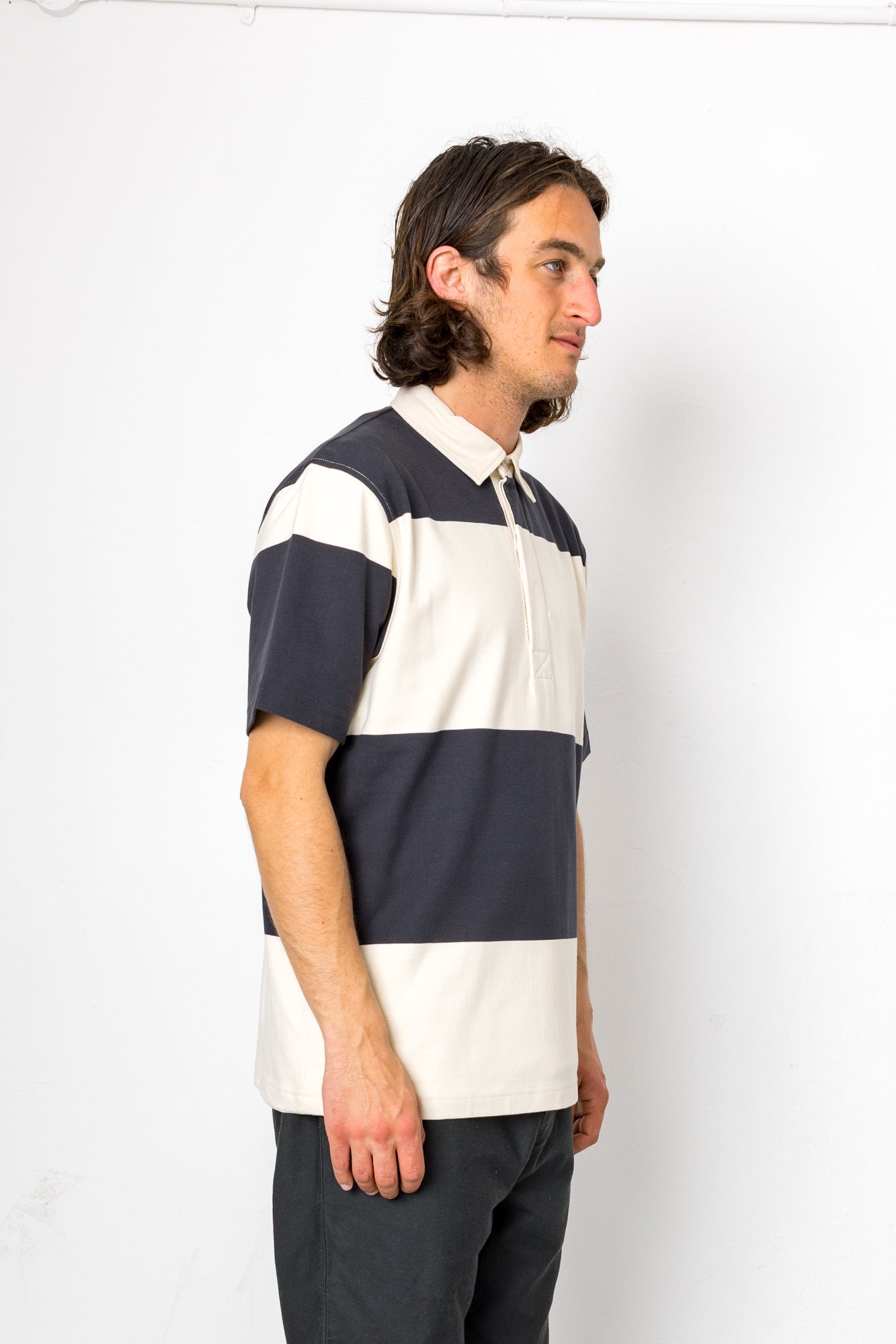 Man wearing a navy and white striped polo shirt against a white background