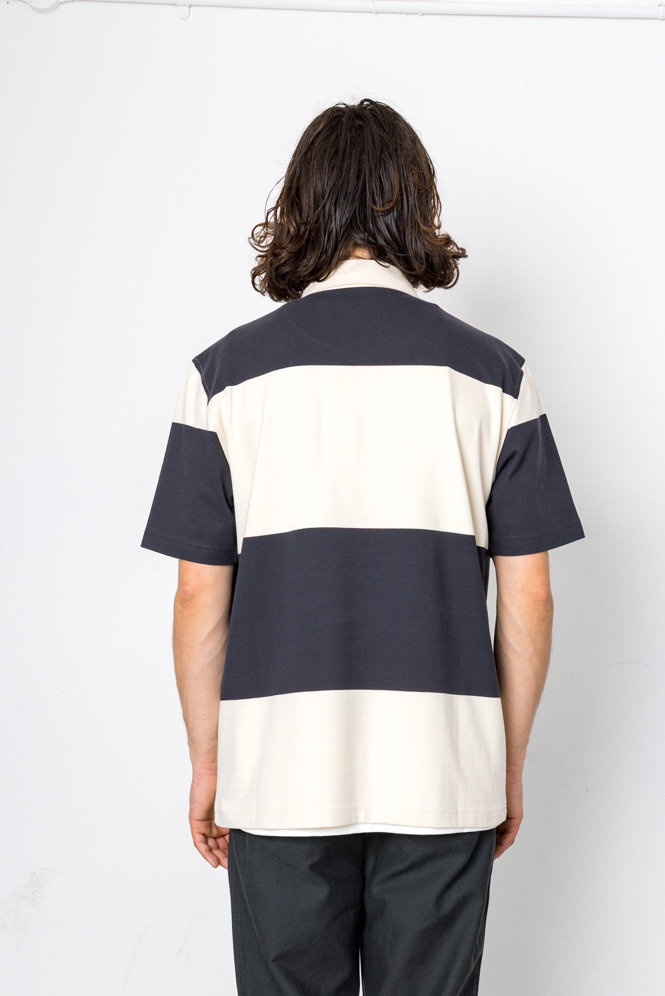 Person wearing a black and white striped shirt on a white background