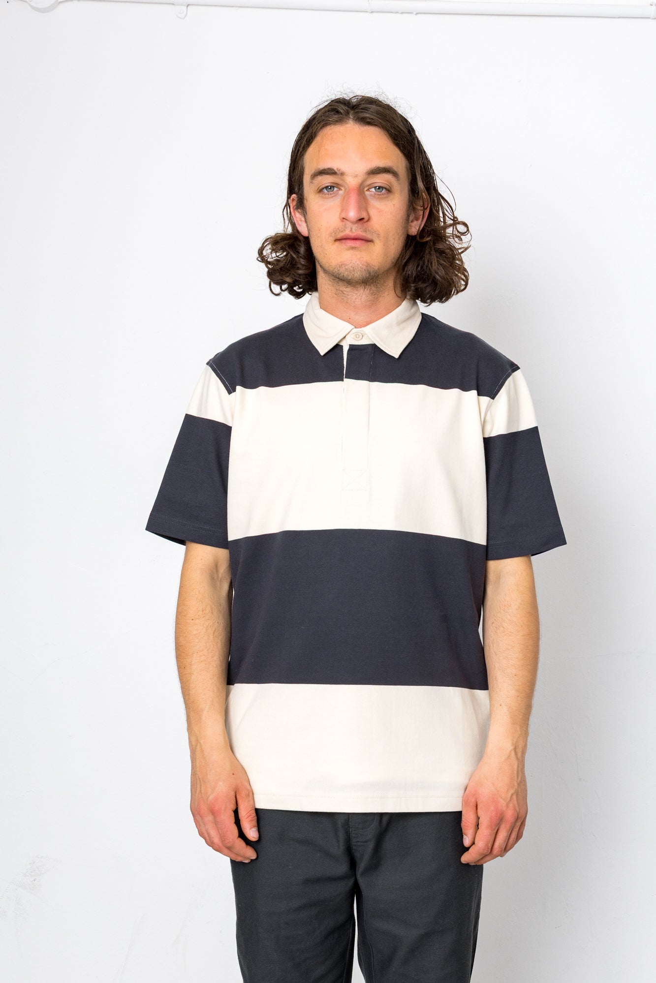 Man wearing a striped polo shirt against a white background