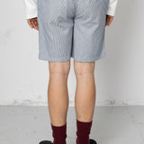 Person wearing light blue shorts and maroon socks on a plain background