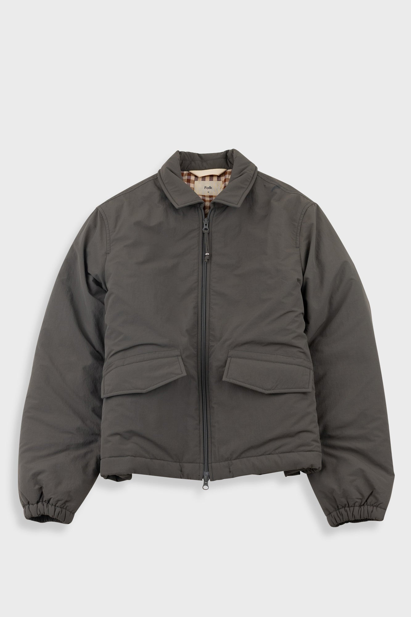 Gray jacket with plaid lining and visible brand name on a white background
