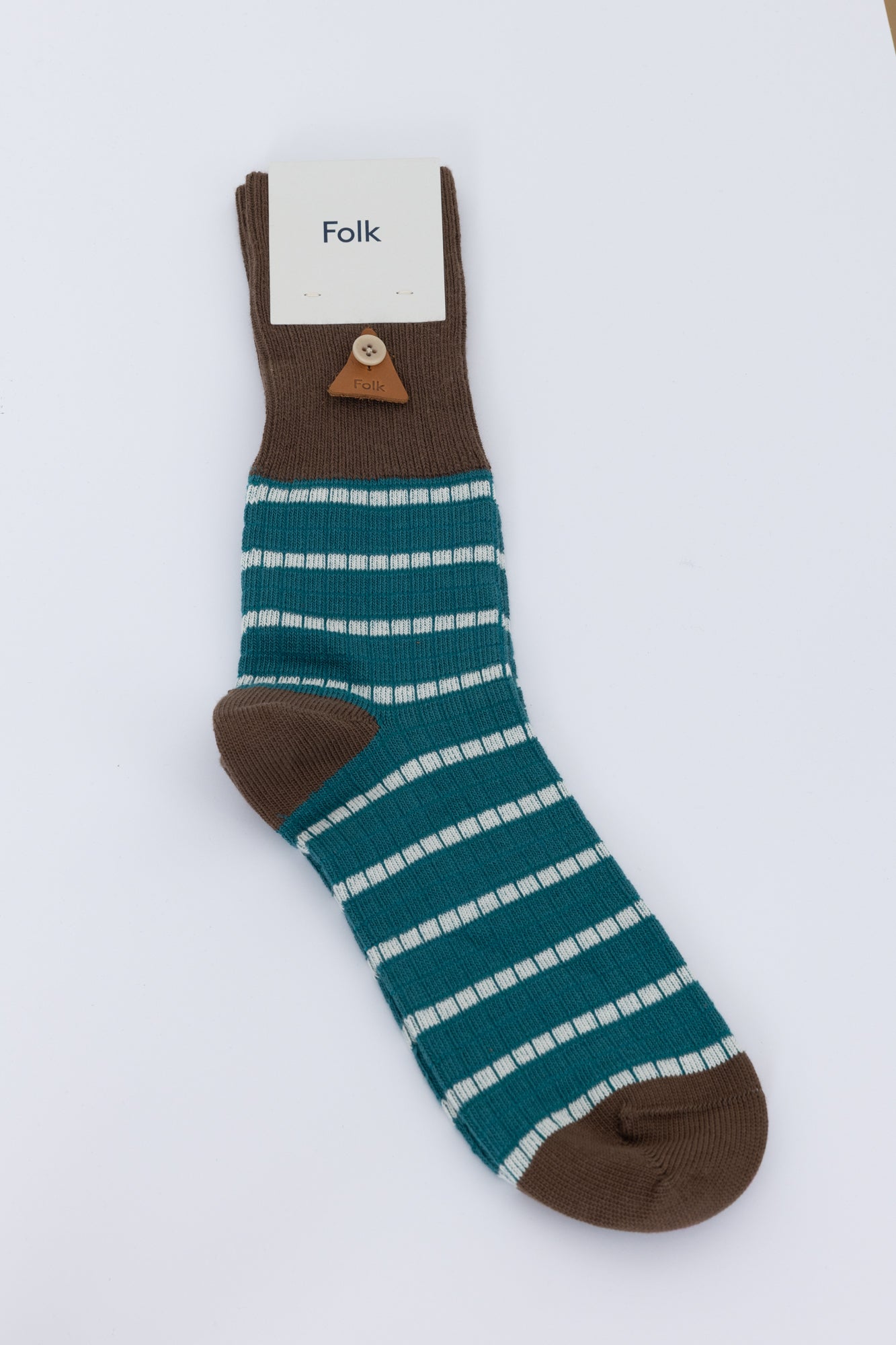 Brown and blue striped sock against a grey background