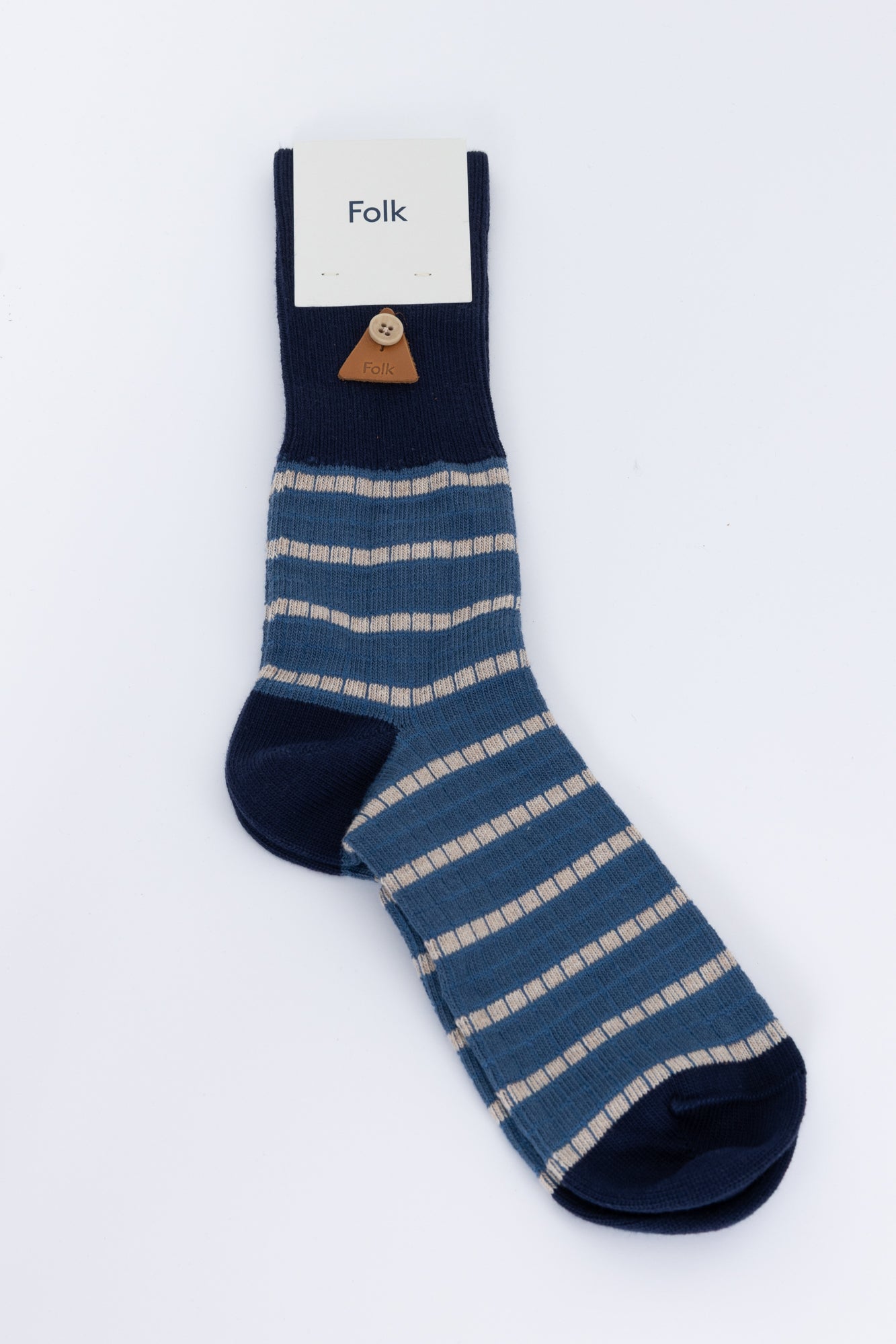 Navy blue sock with beige stripes on a white background, featuring 'Folk' brand label.