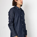 Man wearing a dark denim shirt against a white background