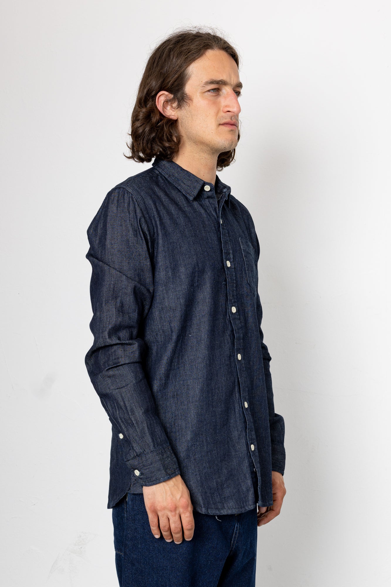 Man wearing a dark denim shirt against a white background
