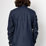Person wearing a dark denim shirt from behind on a white background