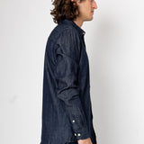 Man wearing a dark denim shirt against a white background