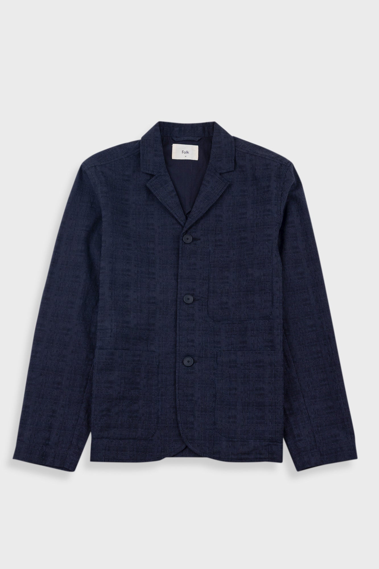 Navy blazer on a light gray background