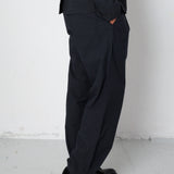 Person wearing a black outfit with wide-leg pants against a white background