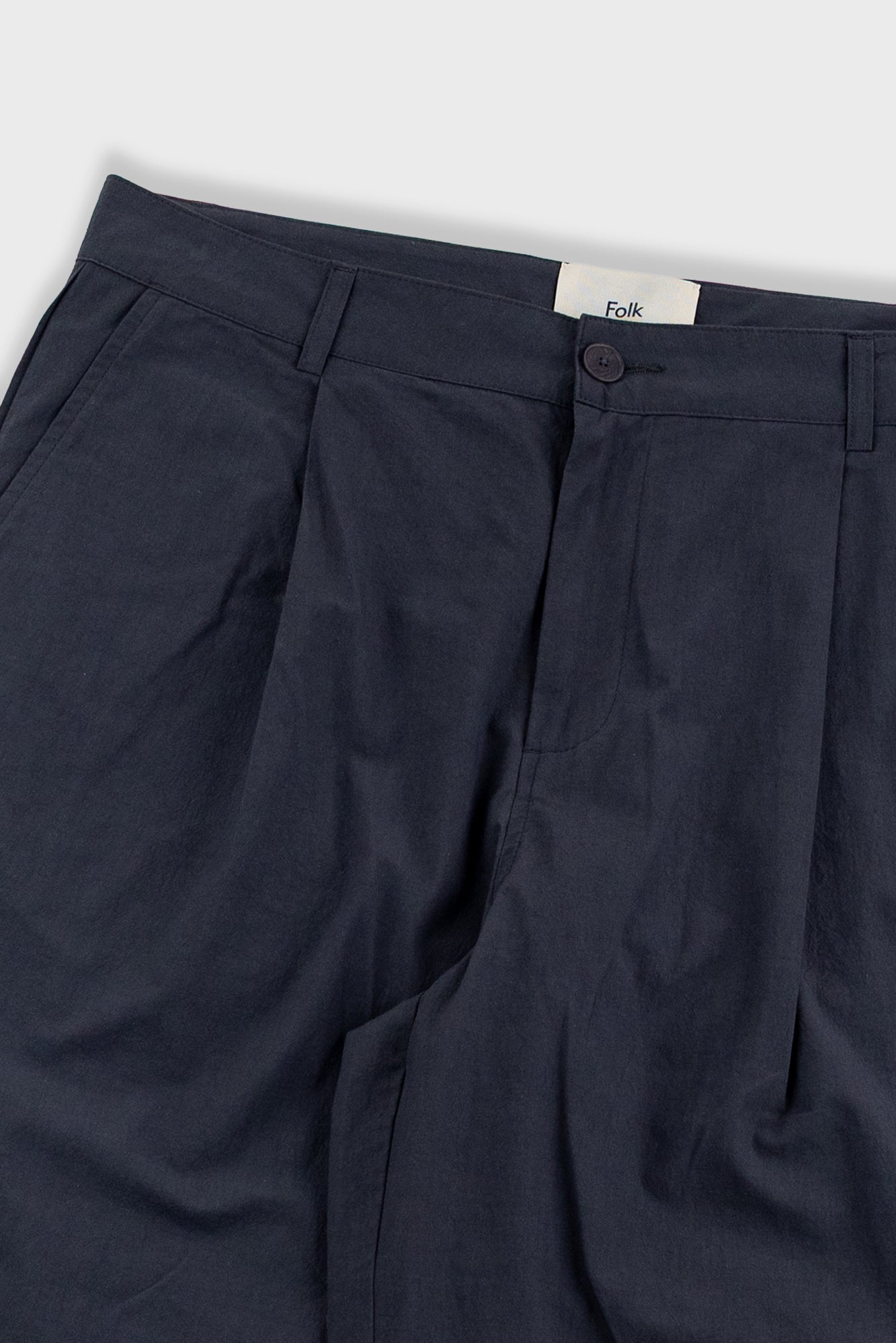 Dark blue pants with a visible brand label on a light gray background
