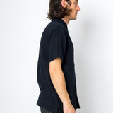 Man wearing a black shirt and gray pants against a white background