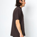 Man wearing a brown shirt against a white background