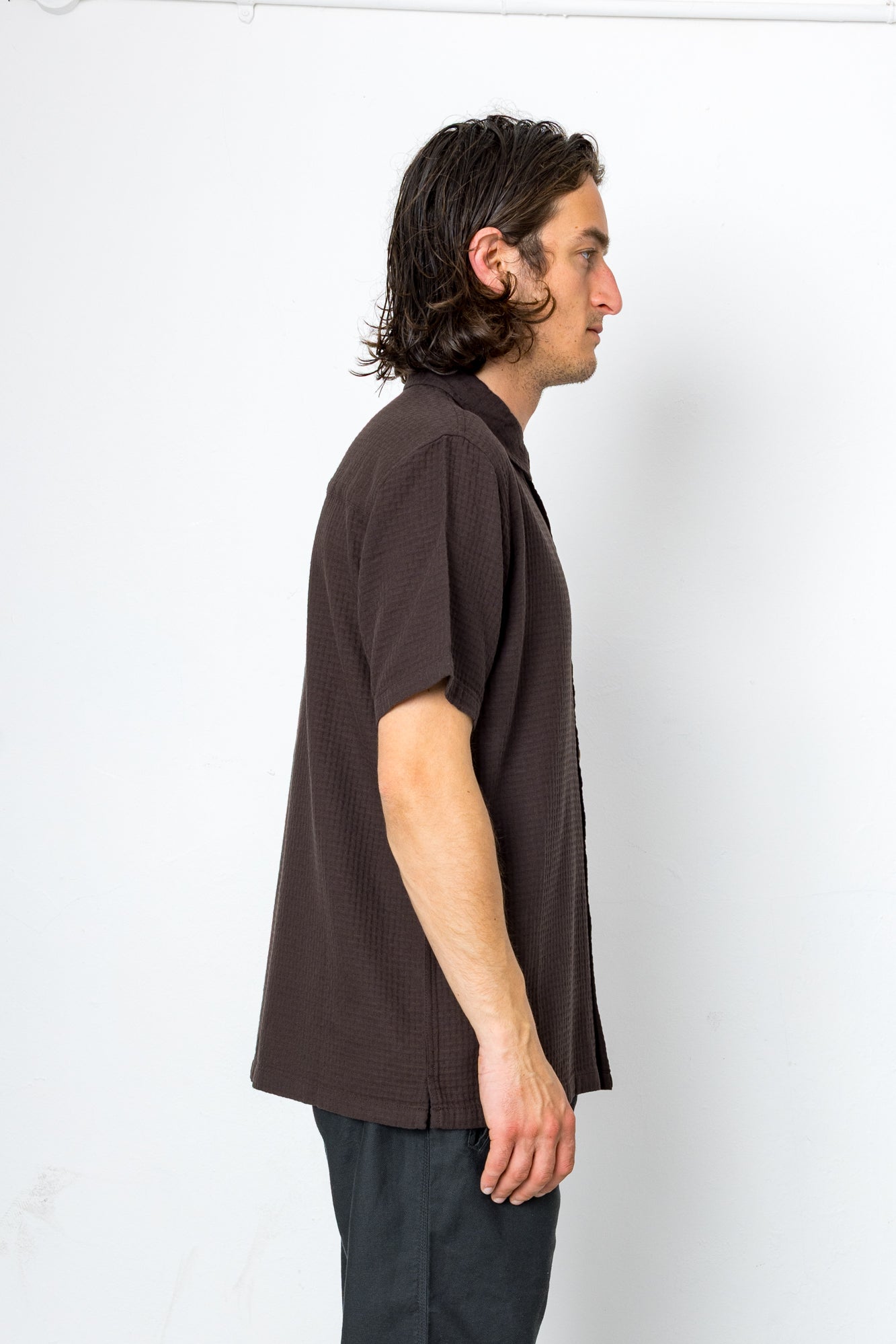 Man wearing a brown shirt against a white background
