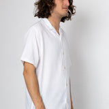 Man wearing a white shirt against a plain background
