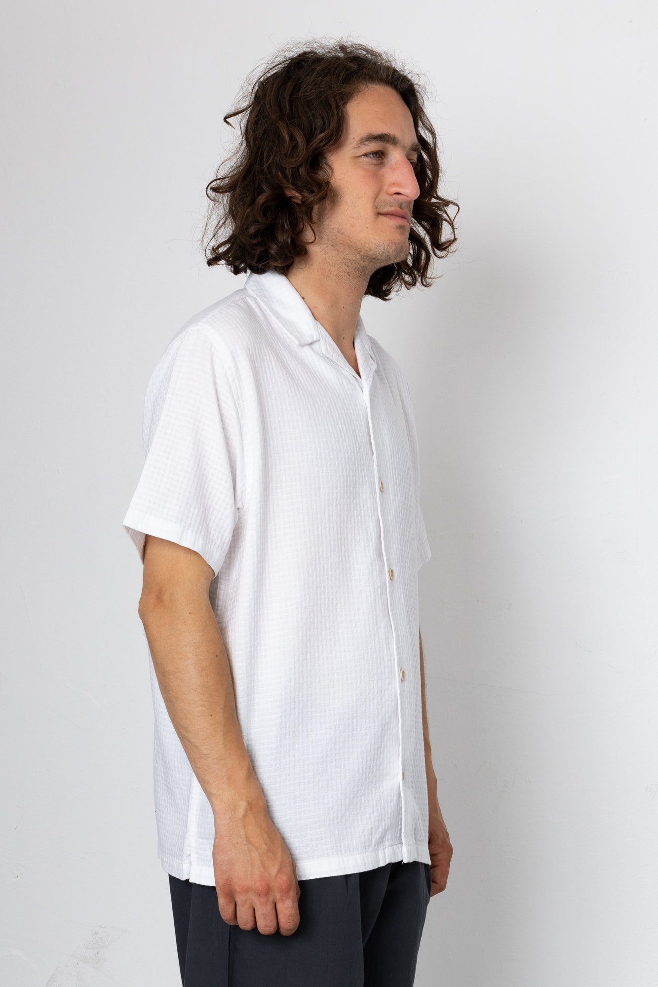 Man wearing a white shirt against a plain background