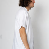 Man wearing a white shirt against a plain background