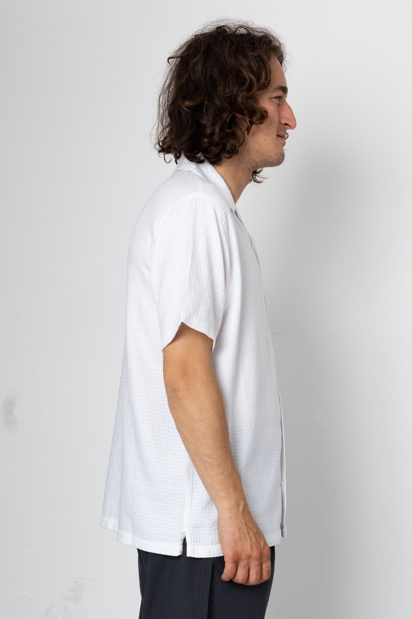 Man wearing a white shirt against a plain background