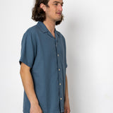 Man wearing a blue shirt against a white background
