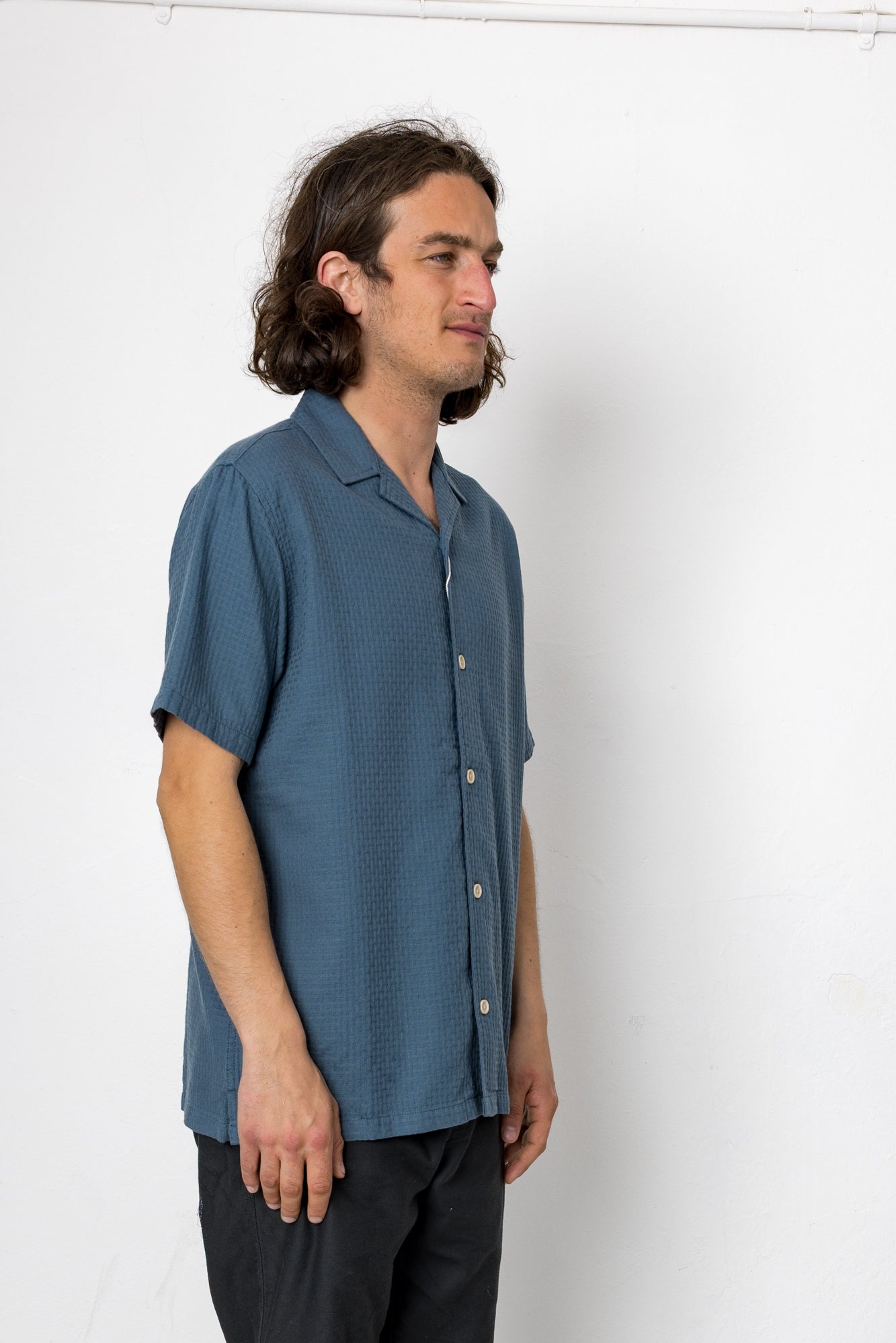 Man wearing a blue shirt against a white background