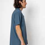Man wearing a blue shirt against a white background