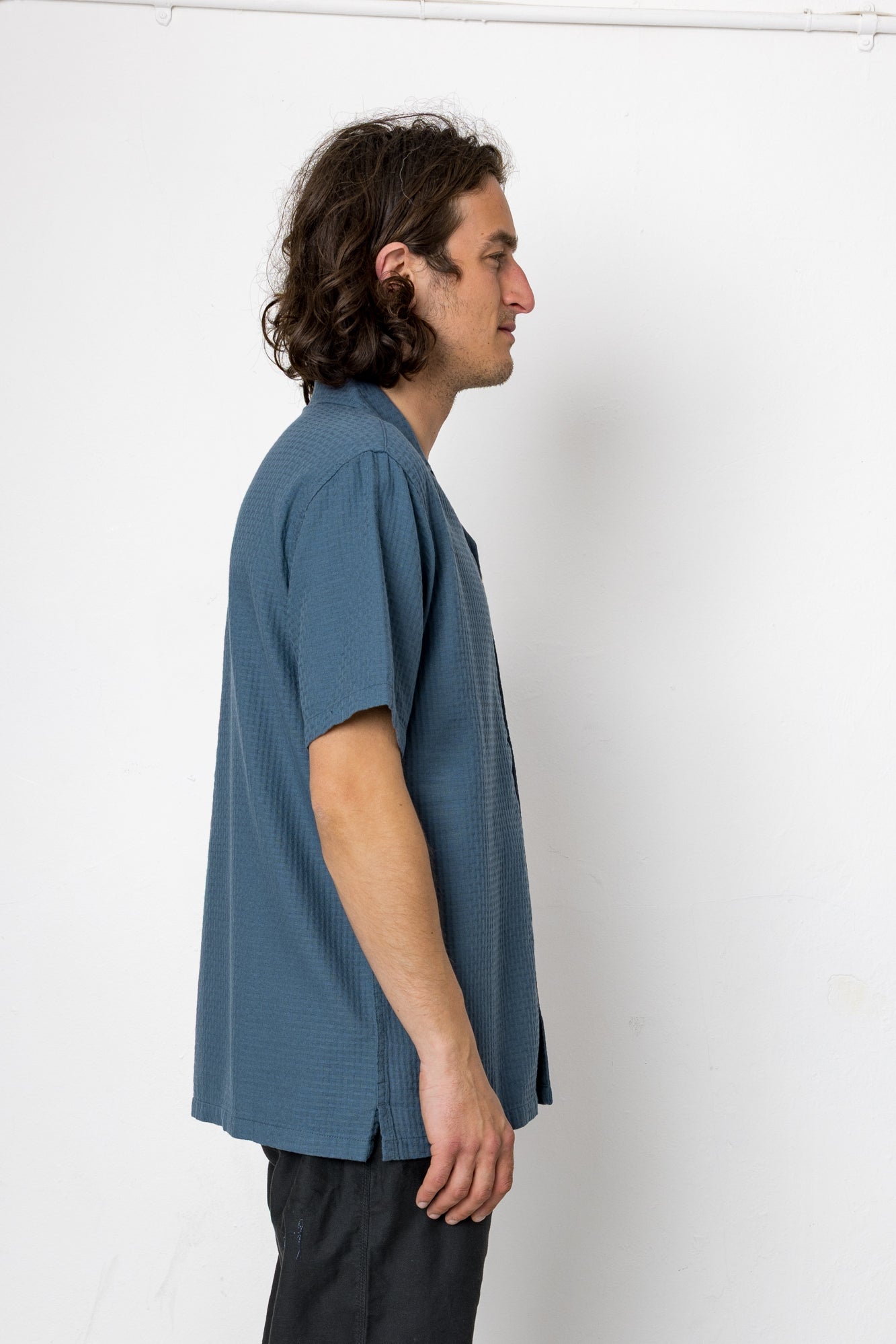Man wearing a blue shirt against a white background