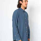 Man wearing a blue button-up shirt against a white background