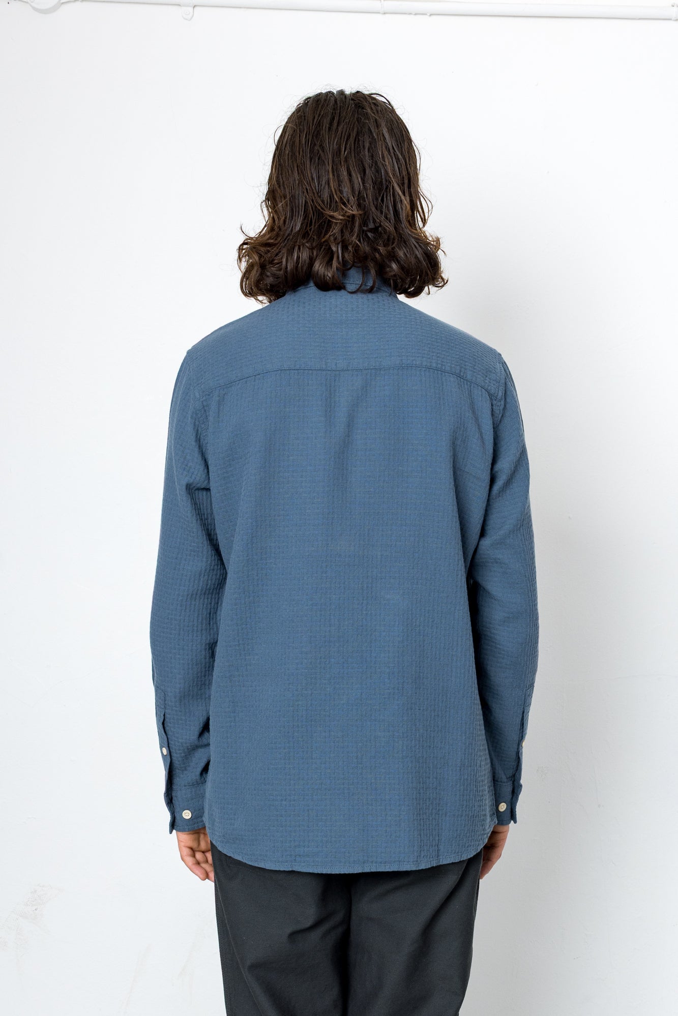 Person wearing a blue shirt with a white background