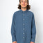 Man wearing a blue button-up shirt against a white background