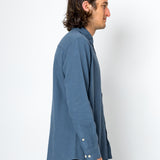 Man wearing a blue textured shirt against a white background