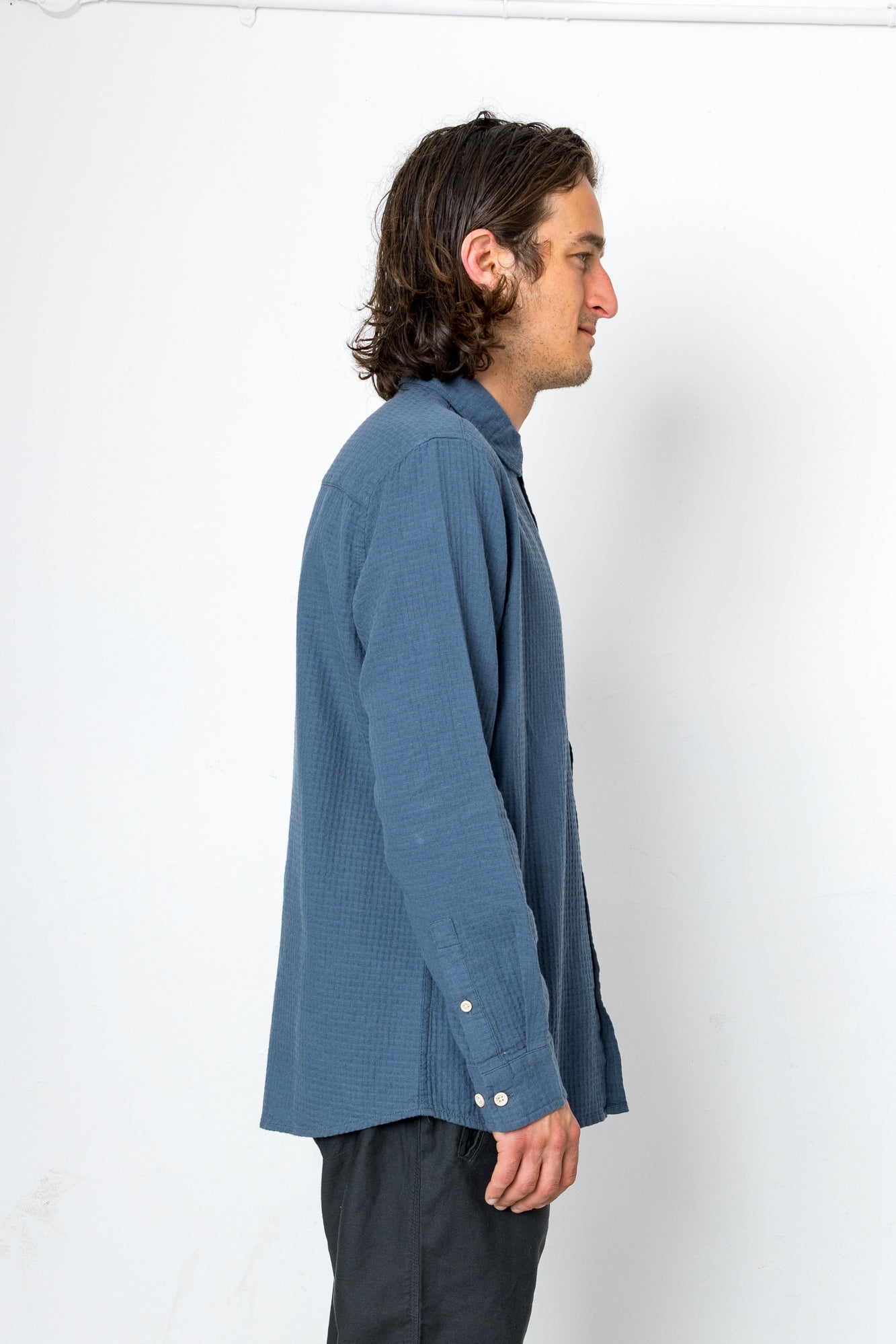 Man wearing a blue textured shirt against a white background