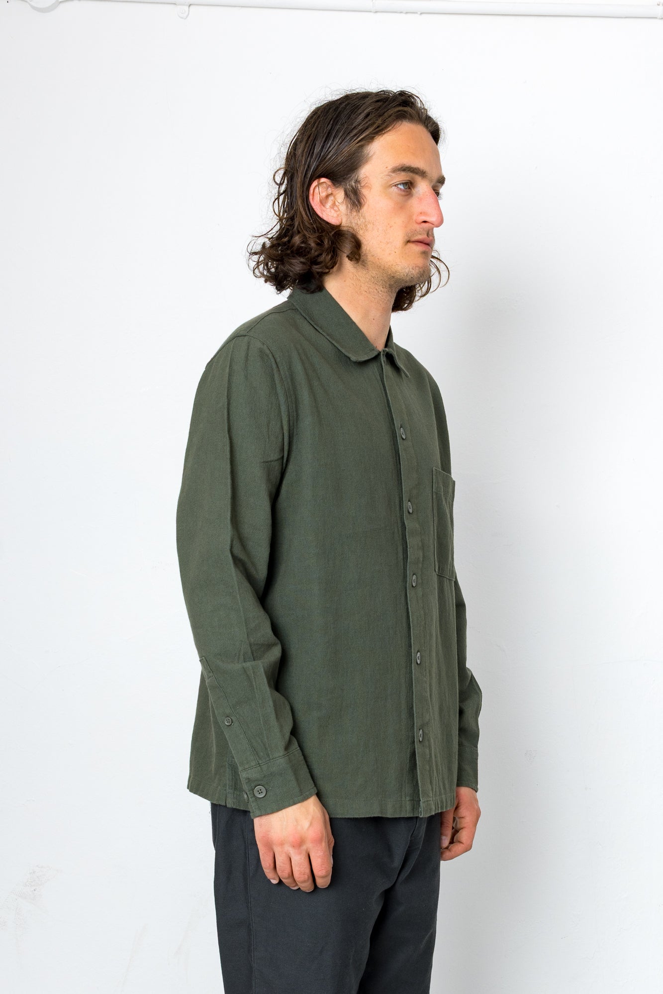 Person wearing a green shirt against a white background