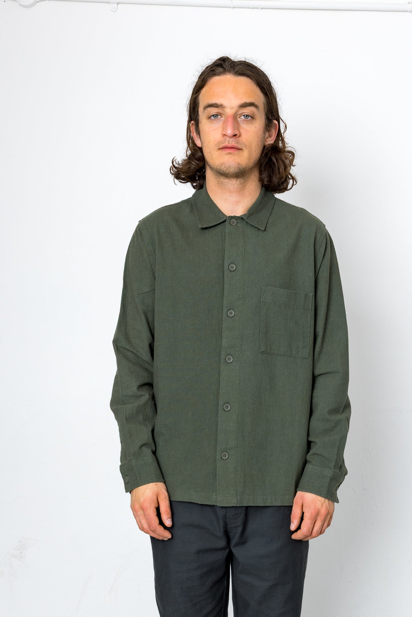 Man wearing a green button-up shirt against a white background