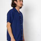 Man wearing a blue shirt against a white background