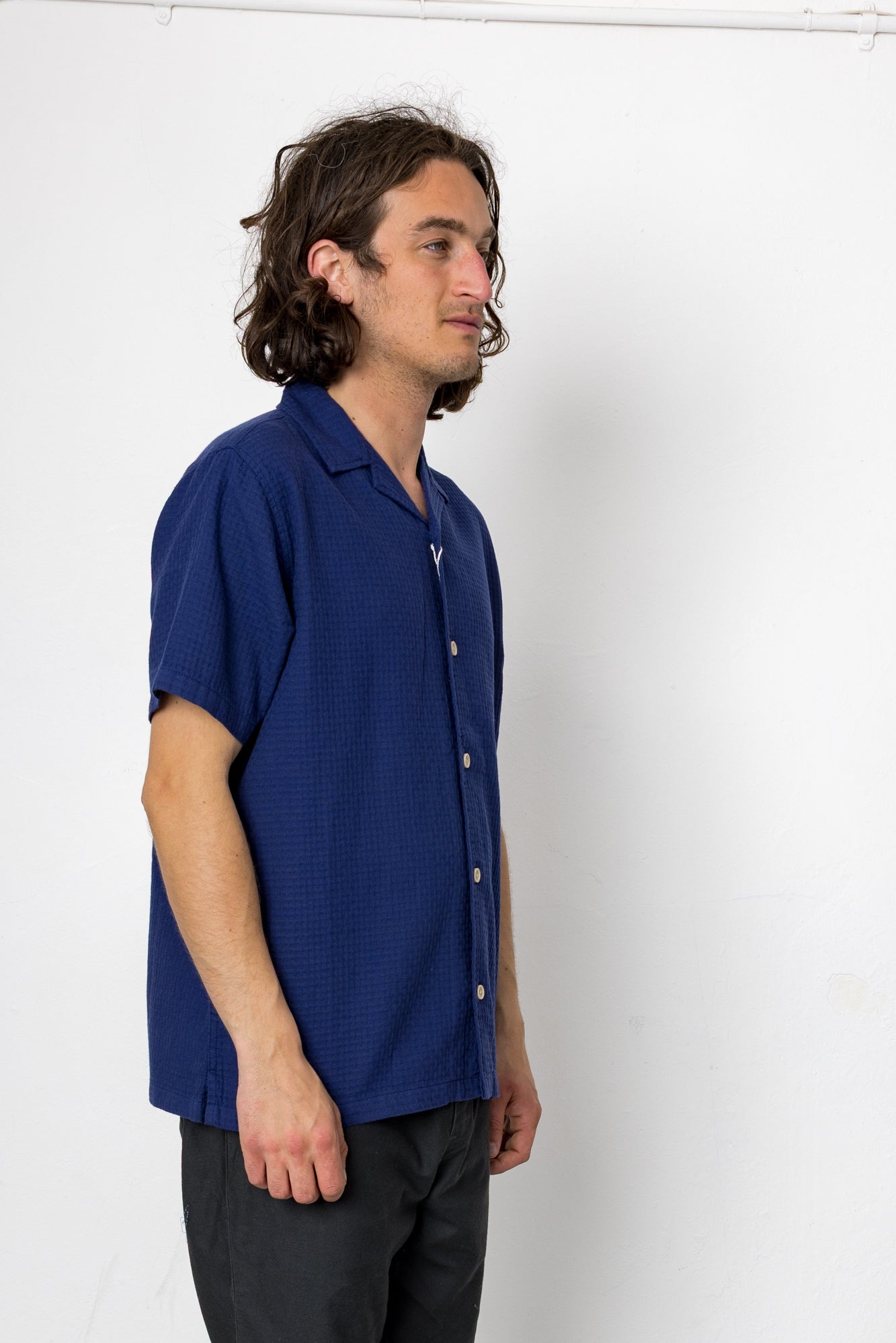 Man wearing a blue shirt against a white background